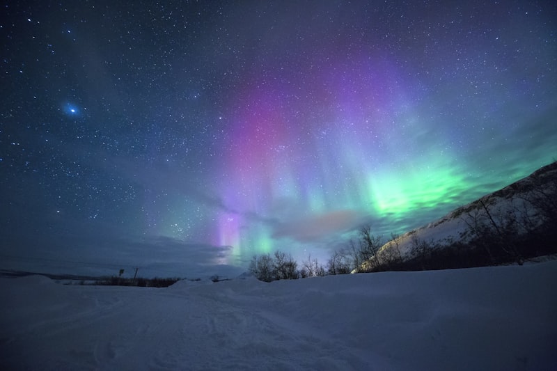 Northern lights over snowy mountains